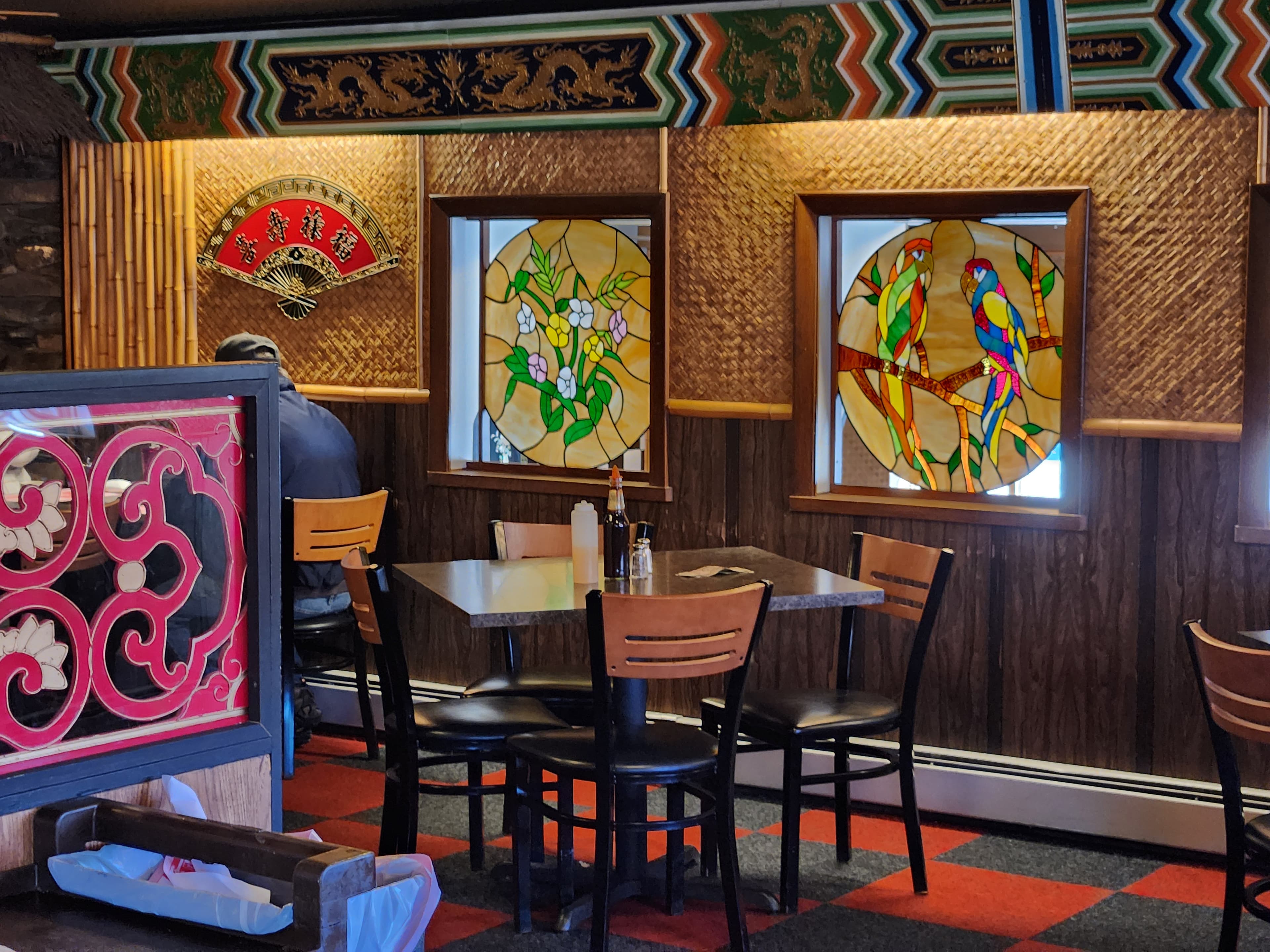 A cozy restaurant interior featuring stained glass windows and wooden decor.