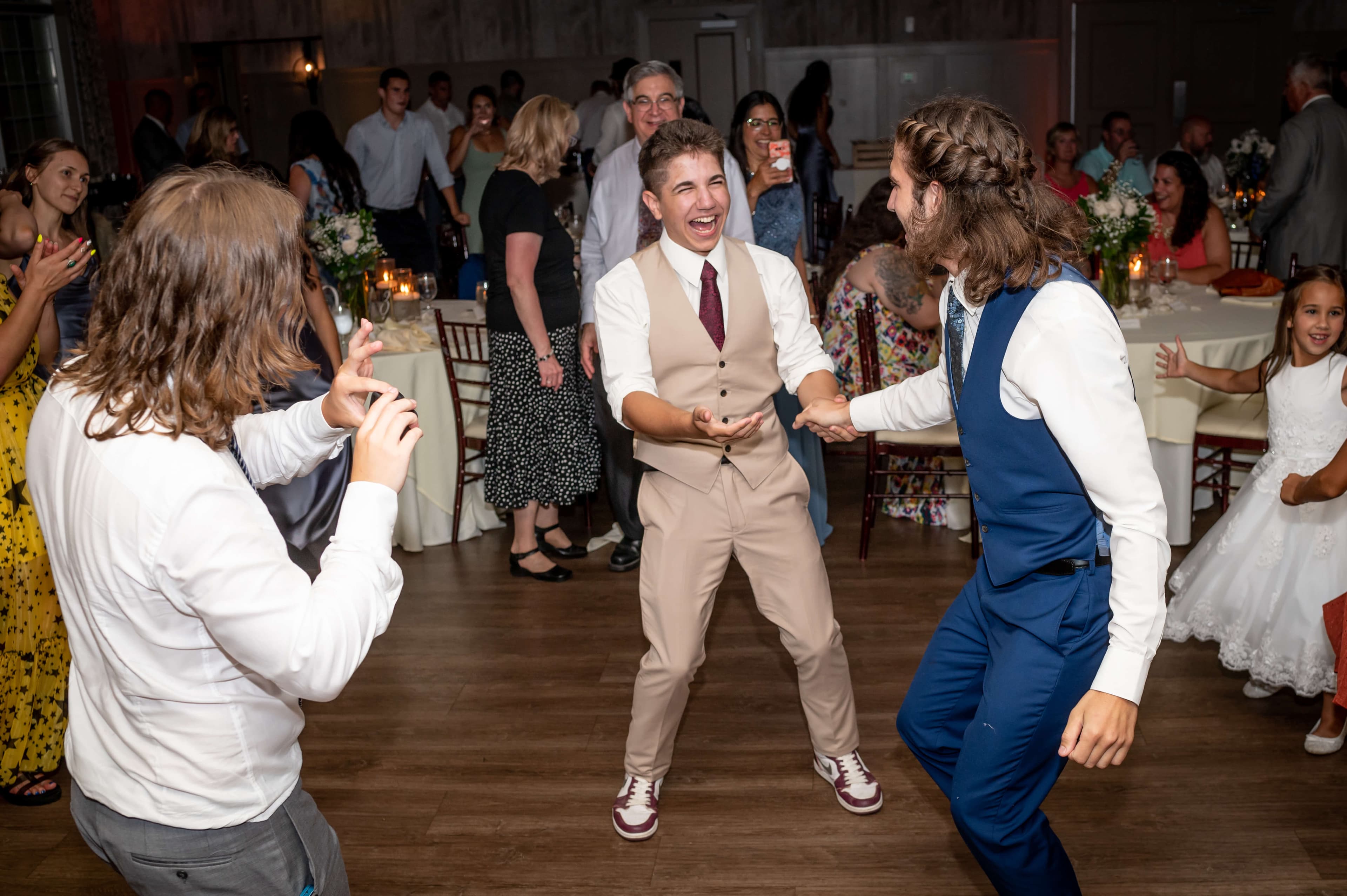 Guests joyfully dance and celebrate at a festive event. Guests joyfully dance and celebrate at a festive event.