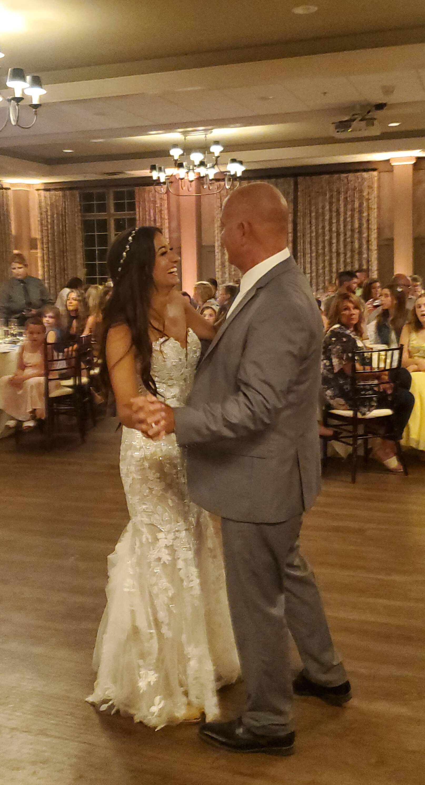 A bride and groom share a joyful dance at their wedding reception.