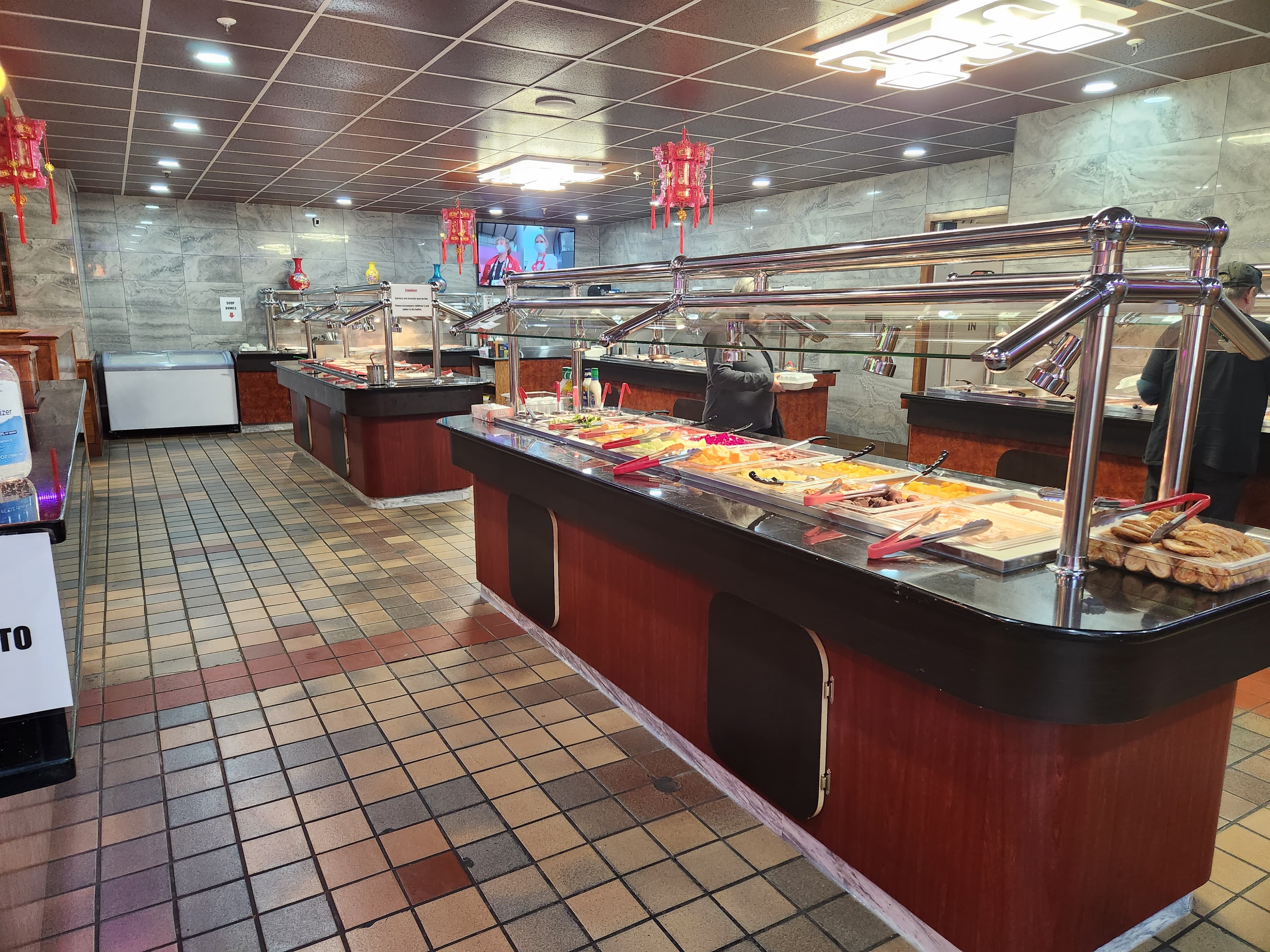 A spacious buffet restaurant showcasing a variety of food options under glass displays.
