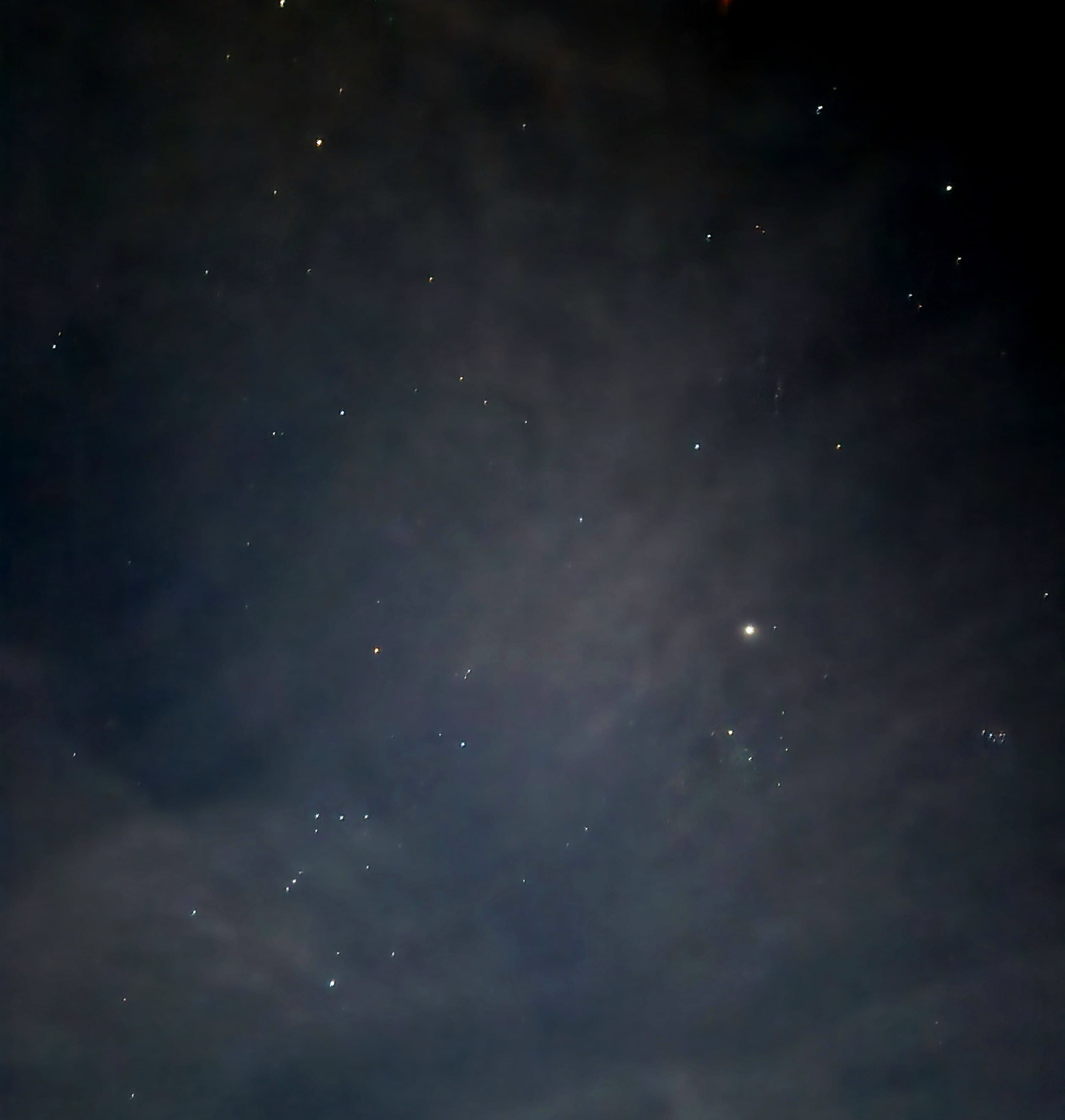 A star-filled night sky with scattered clouds.
