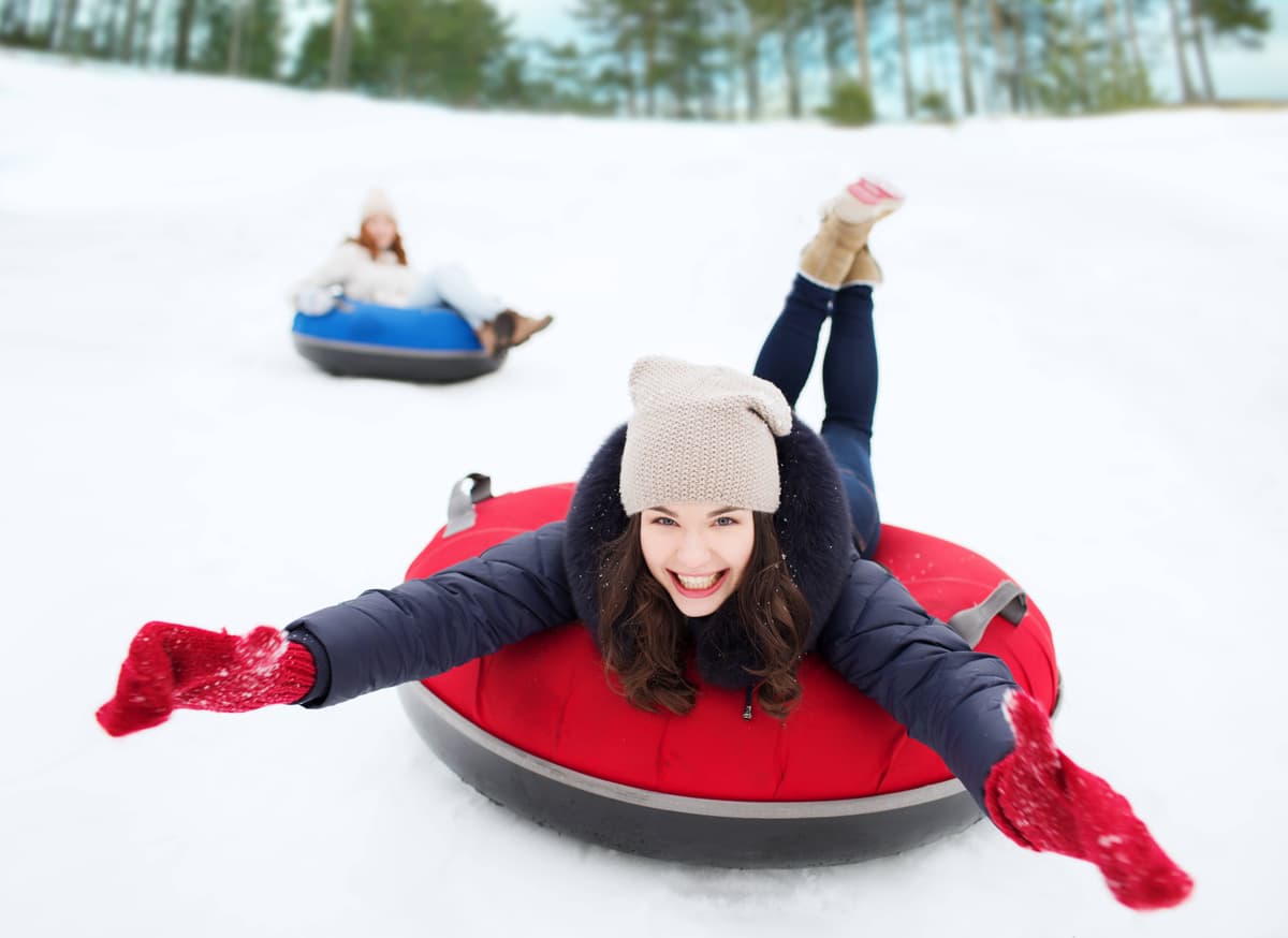 Happy woman snow tubing