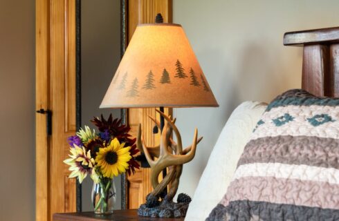Unique deer antler lamp on bedside table with sunflowers in a vase
