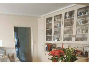 White cupboards with glass doors near a doorway